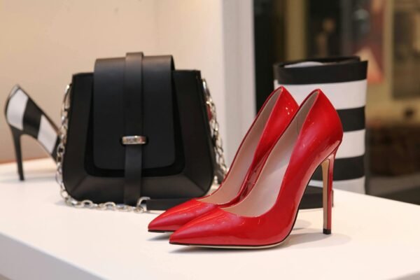 Showcasing sleek red stilettos and a chic black handbag in a luxury boutique setting.